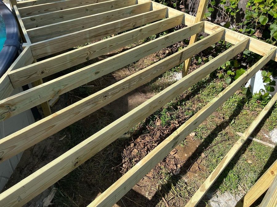 Our own crew framing a deck, joists and hangers going in