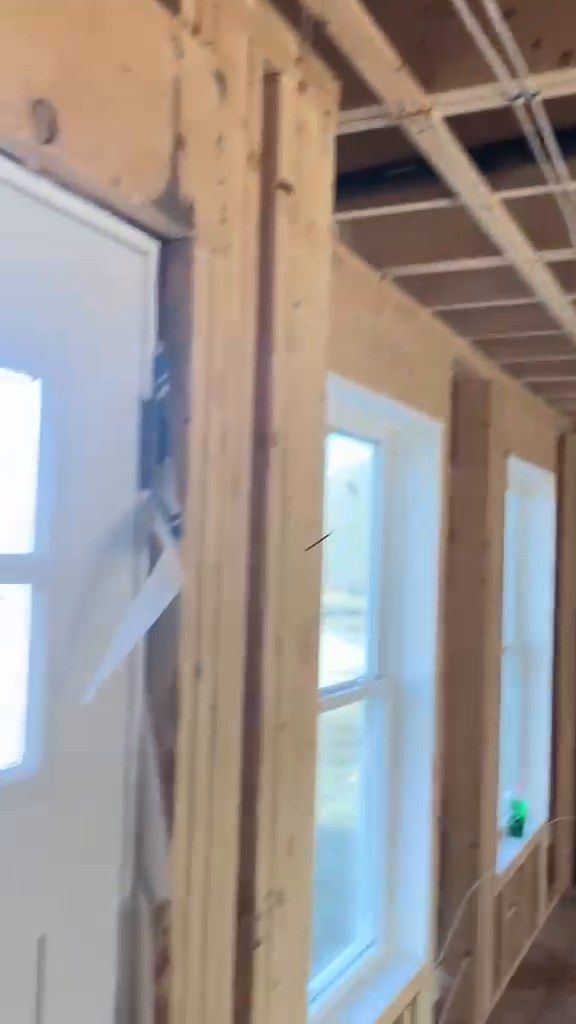 Framed window opening with a new window installed in a house under construction